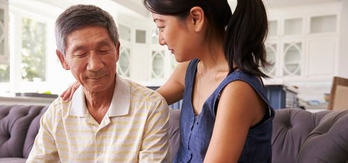 Adult Daughter Talking To Depressed Father At Home
